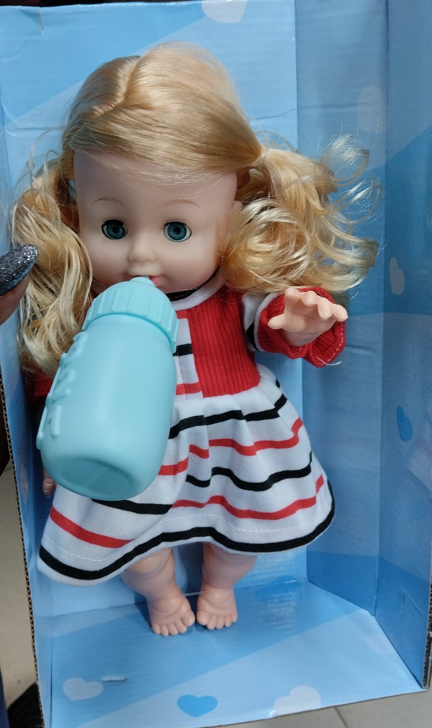 Talking and blinking doll with a feeding bottle